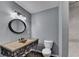 Updated bathroom featuring a vanity with a unique sink, dark fixtures, a round mirror, and an elegant tiled shower at 168 Woodland Valley Rd, Lawrenceville, GA 30046