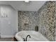 Bathroom showcasing tub with stone accent wall, faucet, and ' ' coat rack at 168 Woodland Valley Rd, Lawrenceville, GA 30046
