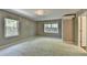 Spacious bedroom with plush carpeting, two windows, and modern lighting at 168 Woodland Valley Rd, Lawrenceville, GA 30046