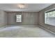 Bright, spacious bedroom with plush carpet, two windows, and modern recessed lighting and beautiful chandelier at 168 Woodland Valley Rd, Lawrenceville, GA 30046