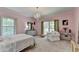 Bedroom features pink walls, chandelier, and lots of natural light at 168 Woodland Valley Rd, Lawrenceville, GA 30046