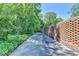 Long driveway lined by a decorative brick wall and mature trees, leading to the property's entrance and adding privacy at 168 Woodland Valley Rd, Lawrenceville, GA 30046