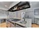 Island cooktop with granite counters and modern fixtures make this gray kitchen luxurious at 168 Woodland Valley Rd, Lawrenceville, GA 30046