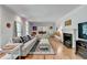 Bright living room with a large comfortable couch, fireplace, and hardwood floors, perfect for relaxing and entertaining at 168 Woodland Valley Rd, Lawrenceville, GA 30046