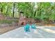 Outdoor patio area featuring a brick fireplace, seating, and lush landscaping for relaxation and entertainment at 168 Woodland Valley Rd, Lawrenceville, GA 30046