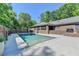 Backyard pool is complemented by a brick wall, lush greenery, and a patio space for relaxing and entertaining at 168 Woodland Valley Rd, Lawrenceville, GA 30046
