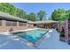 A luxurious backyard pool surrounded by brick walls and lush greenery, perfect for relaxation and entertaining at 168 Woodland Valley Rd, Lawrenceville, GA 30046