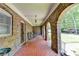 Exterior porch with brick flooring, brick columns, metal decorated door, and rocking chairs at 168 Woodland Valley Rd, Lawrenceville, GA 30046