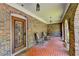 Charming brick porch featuring brick floor, metal decorated door, and rocking chairs at 168 Woodland Valley Rd, Lawrenceville, GA 30046