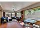 Sunroom with brick accent, dining table, and plush seating is bathed in natural light at 168 Woodland Valley Rd, Lawrenceville, GA 30046