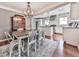 Open dining room area with a farmhouse-style table, chandelier, and access to a modern kitchen at 2660 Birch Se St, Smyrna, GA 30080