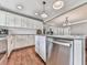 Open-concept kitchen with stainless steel dishwasher, granite countertops, and white cabinets at 2660 Birch Se St, Smyrna, GA 30080