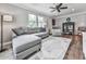 Cozy living room featuring a grey sectional sofa, ceiling fan, and hardwood floors at 2660 Birch Se St, Smyrna, GA 30080