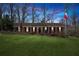 Charming brick ranch home with manicured lawn, mature trees, and welcoming front porch at dusk at 3250 North Embry Cir, Chamblee, GA 30341