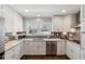 Well-lit kitchen with white cabinets, stainless steel appliances, granite countertops, and wood flooring at 3250 North Embry Cir, Chamblee, GA 30341