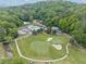 Scenic aerial view of a lush golf course, swimming pool, and surrounding wooded landscape at 357 Breeze Hill Ln, Canton, GA 30114