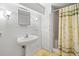 Bathroom with pedestal sink, mirror, and shower with patterned curtain at 357 Breeze Hill Ln, Canton, GA 30114