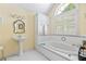 Bright bathroom featuring a garden tub and natural light from a window at 357 Breeze Hill Ln, Canton, GA 30114