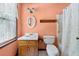 Bathroom with floral shower curtain, single sink vanity, window with lace curtains, and peach walls at 357 Breeze Hill Ln, Canton, GA 30114