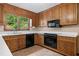 Traditional kitchen features wood cabinetry, white countertops, and black appliances at 357 Breeze Hill Ln, Canton, GA 30114