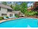 A backyard swimming pool is surrounded by lounge chairs, patio furniture, and lush greenery at 357 Breeze Hill Ln, Canton, GA 30114