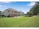Expansive backyard showcases the home's exterior, covered patio, fire pit area, and playground, offering space for recreation at 4285 Hunters Walk Way, Cumming, GA 30028