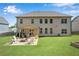 Rear view of home highlighting the covered patio, outdoor seating around a firepit and ample yard space at 4285 Hunters Walk Way, Cumming, GA 30028
