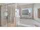 Well-lit bathroom features soaking tub, glass shower, and tiled walls at 4285 Hunters Walk Way, Cumming, GA 30028
