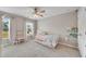 Charming bedroom with a daybed, ceiling fan, and natural light from the windows at 4285 Hunters Walk Way, Cumming, GA 30028