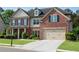 Traditional-style home showcasing brick and siding exterior, garage, and manicured landscaping at 4285 Hunters Walk Way, Cumming, GA 30028