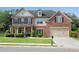 Charming two-story home with a brick facade, well-manicured lawn, and attached two-car garage at 4285 Hunters Walk Way, Cumming, GA 30028