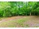 The large backyard features mature trees and space for outdoor activities at 2249 Hill Creek Way, Marietta, GA 30062