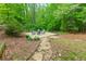 Backyard featuring stone patio area with seating and mature landscaping at 2249 Hill Creek Way, Marietta, GA 30062