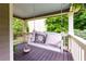 A charming porch swing with decorative pillows offers a cozy spot to enjoy the serene outdoor view at 2249 Hill Creek Way, Marietta, GA 30062