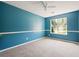 Bedroom with grey carpet, blue walls, and views of the backyard at 648 Bellingham Dr, Sugar Hill, GA 30518