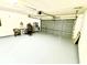 Spacious two-car garage with ample room for parking and storage, featuring a light-colored floor at 648 Bellingham Dr, Sugar Hill, GA 30518