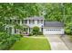 Charming two-story home with a well-manicured lawn and a two-car garage nestled among mature trees at 870 Richmond Hill Dr, Marietta, GA 30068