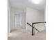 Upstairs hallway featuring neutral carpet, white walls, and a dark railing at 870 Richmond Hill Dr, Marietta, GA 30068