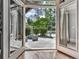 View through open patio doors to stone patio, seating, grill, and landscaped backyard at 1110 Parkview Se Pl, Smyrna, GA 30080
