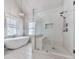 Bright bathroom with stand alone tub, glass enclosed shower, and tile flooring at 1110 Parkview Se Pl, Smyrna, GA 30080