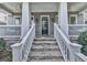 Inviting front porch with stone steps, white railings, ceiling fans, and black door, enhancing curb appeal at 1110 Parkview Se Pl, Smyrna, GA 30080
