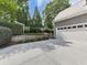 Side exterior view of a house featuring an attached garage and lush landscaped yard at 1110 Parkview Se Pl, Smyrna, GA 30080