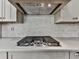 Close-up of the kitchen featuring a gas cooktop, tile backsplash, and elegant countertop at 1110 Parkview Se Pl, Smyrna, GA 30080
