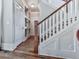 Well-lit staircase with hardwood floors, white risers, and a wood-stained banister at 1110 Parkview Se Pl, Smyrna, GA 30080