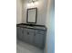 Chic bathroom vanity featuring sleek gray cabinetry, a dark countertop, modern fixtures, and stylish tile flooring at 149 Silvercrest Dr, Acworth, GA 30101
