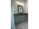 Elegant bathroom vanity with gray cabinetry, dark countertop, modern lighting, and stylish tile flooring at 149 Silvercrest Dr, Acworth, GA 30101