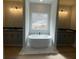 Relaxing main bathroom featuring a standalone tub between and vanities and a large window at 149 Silvercrest Dr, Acworth, GA 30101