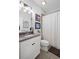 Bright bathroom with single sink vanity, framed mirrors, and shower with patterned curtain at 214 Bluestone Dr, Woodstock, GA 30188