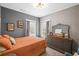 Comfortable bedroom featuring gray walls, wood floors, and a stylish dresser with mirror at 214 Bluestone Dr, Woodstock, GA 30188