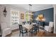 Charming dining room showcases a modern chandelier, bright window, and a decorative brick wall at 214 Bluestone Dr, Woodstock, GA 30188